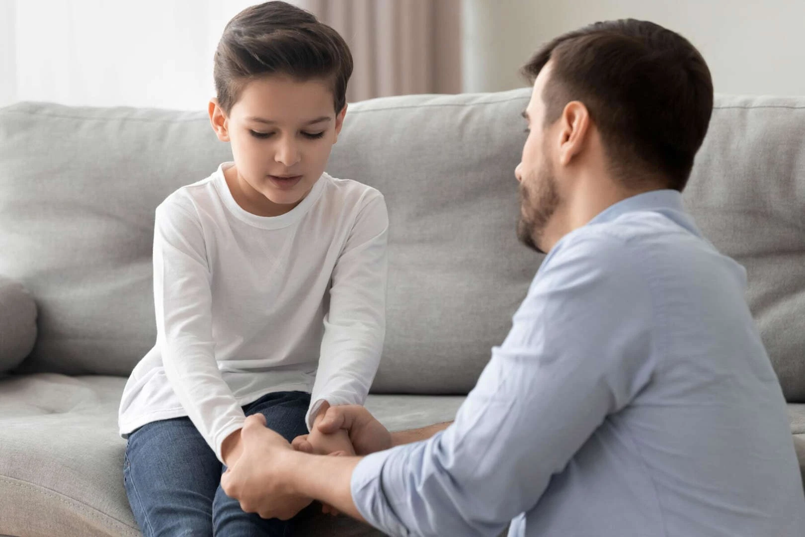 Father consoling son on couch while going through separation