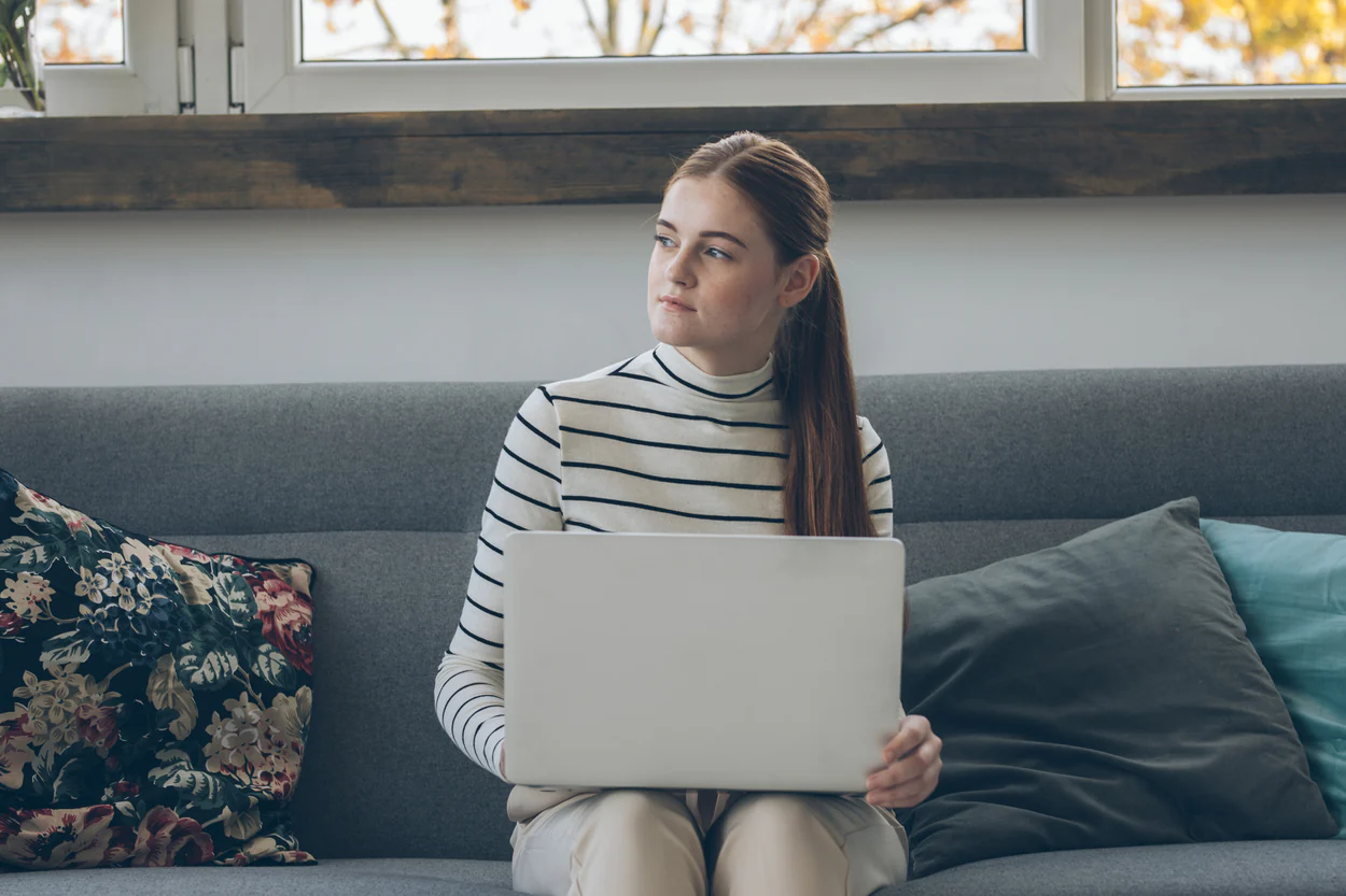 Young woman on laptop on couch