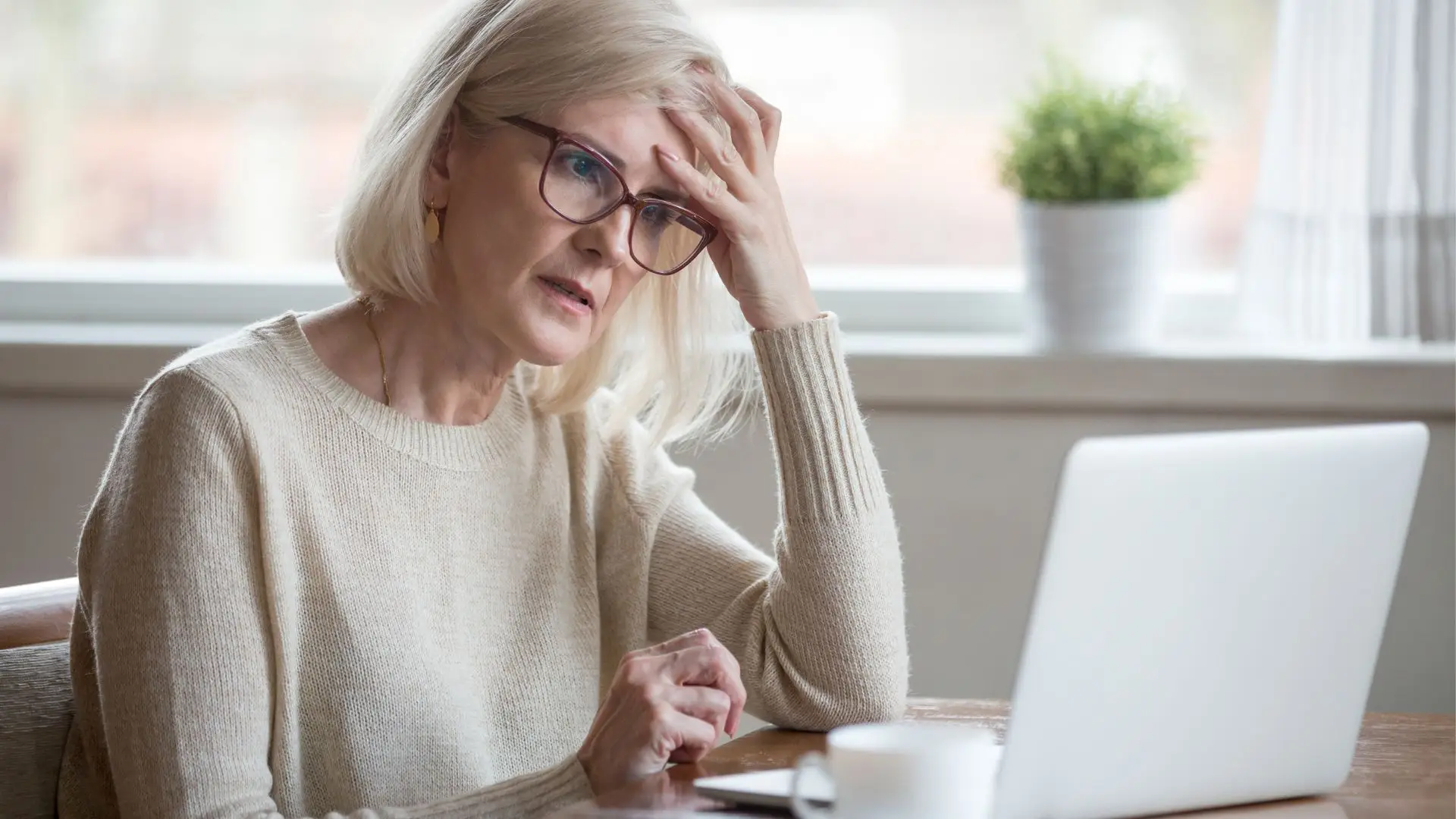 Middle ages woman looking for divorce help on her laptop