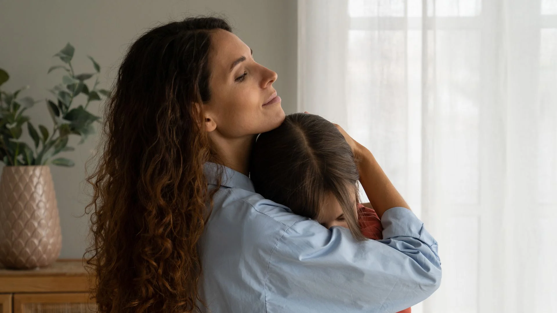 Mother and young daughter embracing during a separation