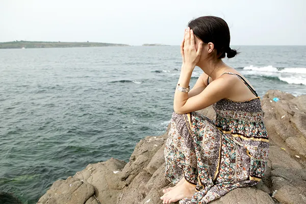 Young woman at the ocean in despair