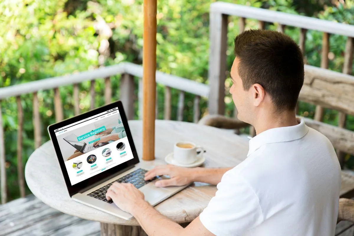 man working on laptop while on holiday
